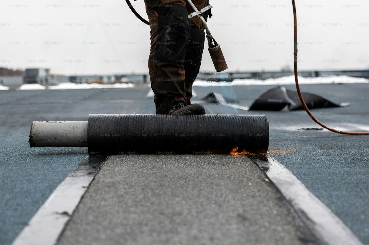 Roofer installing membrane on a commercial flat roof