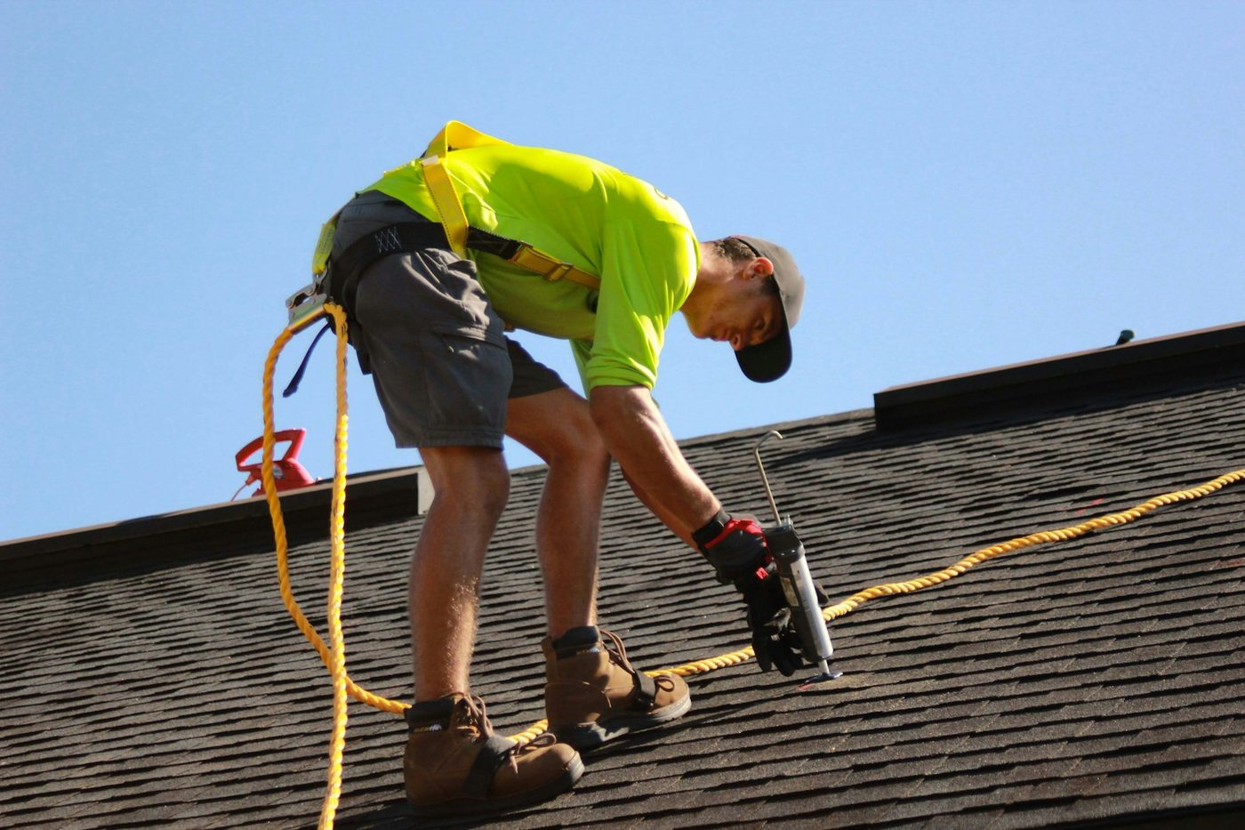 Roofer fastening new shingles during a residential roof replacement